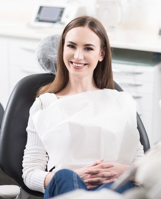 Woman smiling while receiving dentistry in Avon