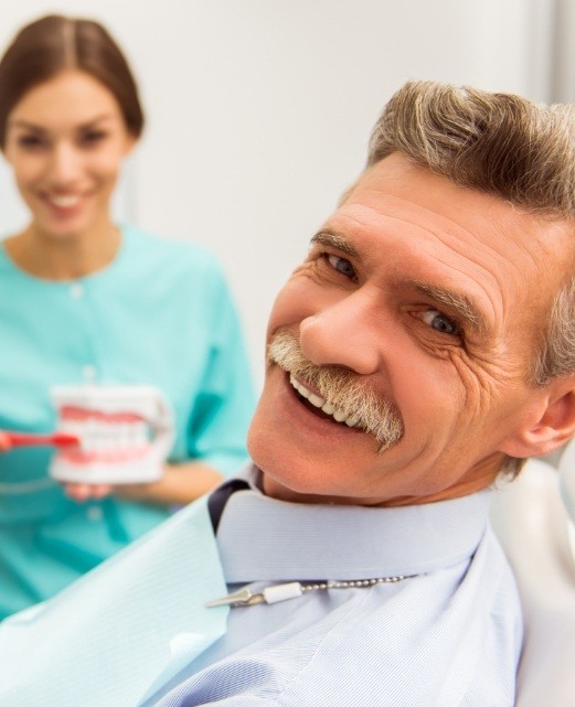 Man smiling while receiving dental services