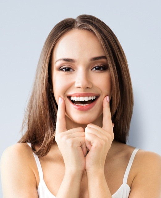 Woman pointing to newly restored smile