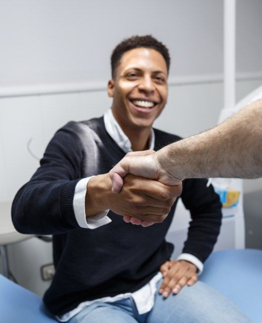 Man shaking hands with dentist after receiving dentistry in Brielle