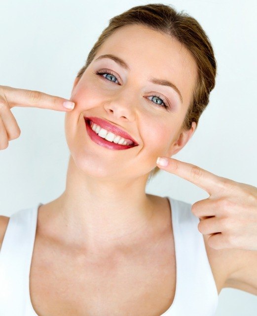 Woman pointing to smile after dental restoration