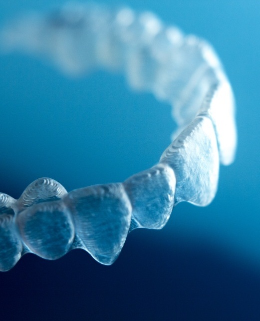 Clear aligner tray on a blue background