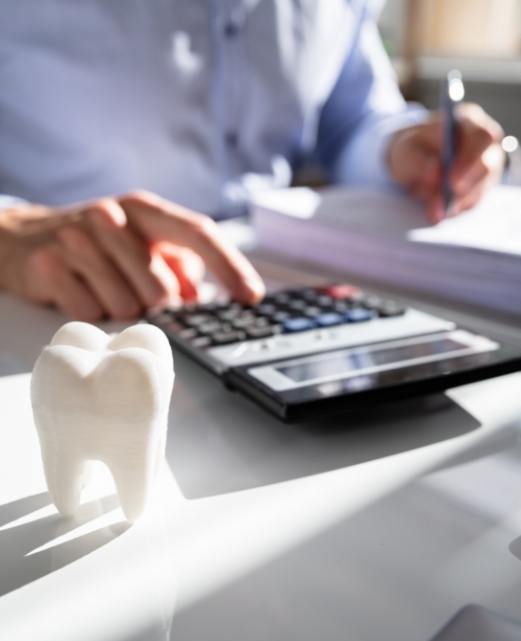 Dental team member calculating dnetal insurance coverage