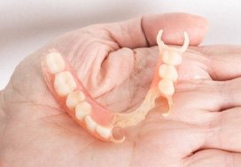 Hand holding partial denture