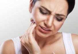 Woman with toothache holding cheek