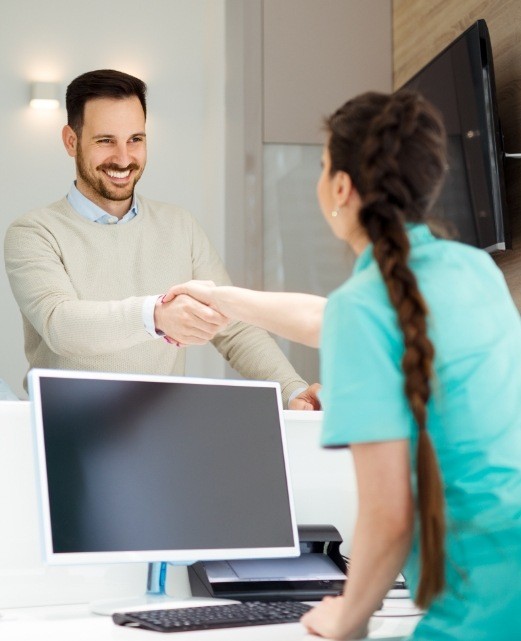 Man shaking hands with dental team member