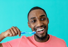 Man holding a toothbrush and smiling