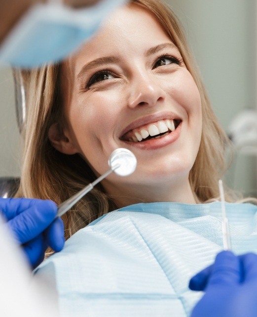Woman smiling during dental checkup and teeth cleaning visit
