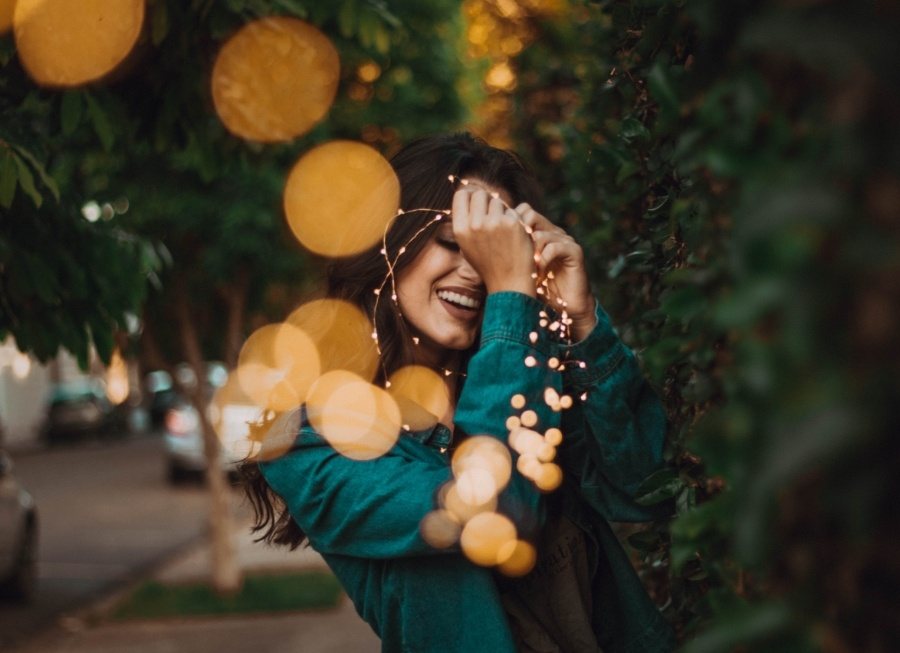 Woman with healthy smile outdoors after receiving dental services