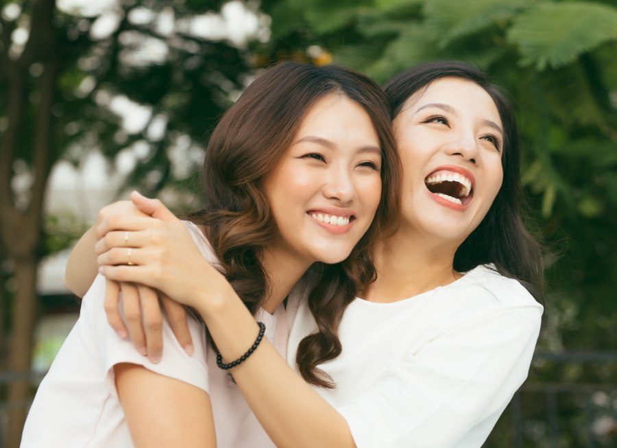 Two women smiling after tooth colored filling restoration