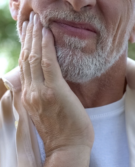 Man in pain holding his cheek