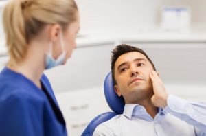 Dentist and patient rubbing jaw