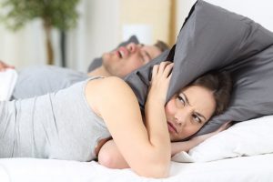woman annoyed at snoring man