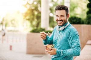 Smiling man with beautiful smile eating a healthy snack