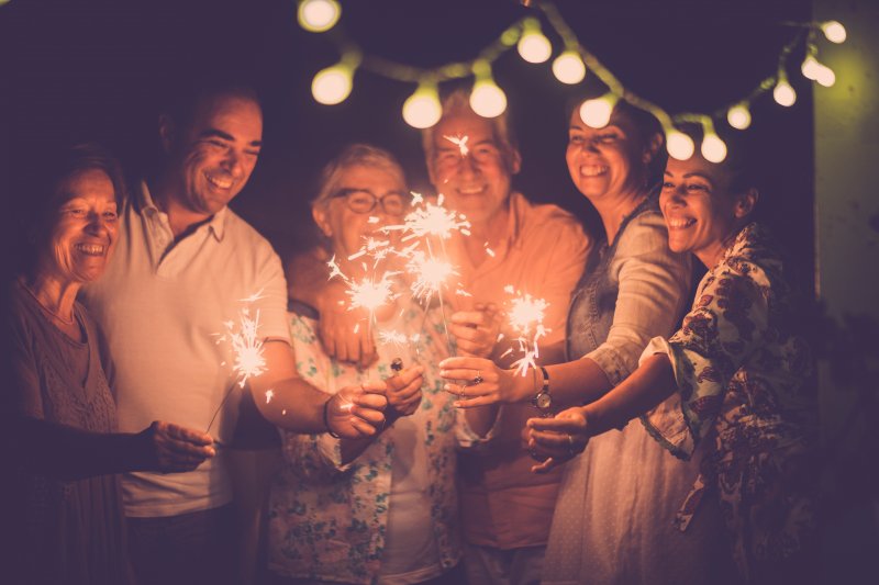 family holding sparklers and smiling