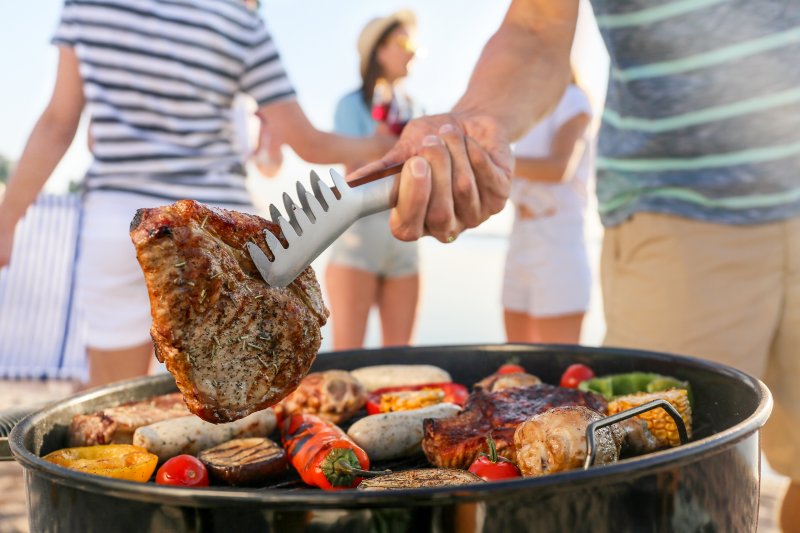 Man grilling summer foods with friends and family