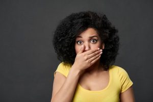 Woman covering mouth with hand should see dentist near Wall Tonwnship