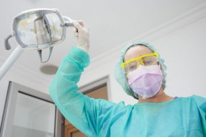 a dentist in Spring Lake wearing personal protective equipment before administering treatment to a patient