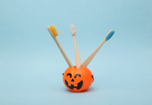 Three wooden toothbrushes in a plastic jack-o-lantern. 