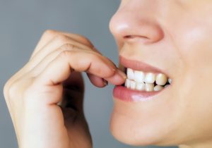 a woman chewing on her nails