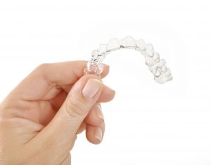 hand holding Invisalign aligner