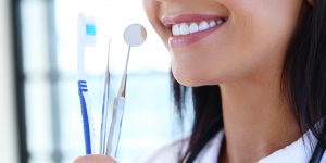 Woman holding a toothbrush and floss